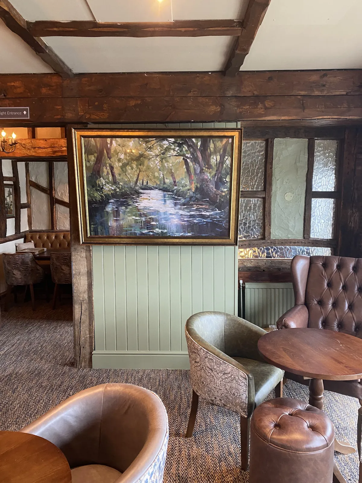 Beamed room with green painted panelling and a framed painting