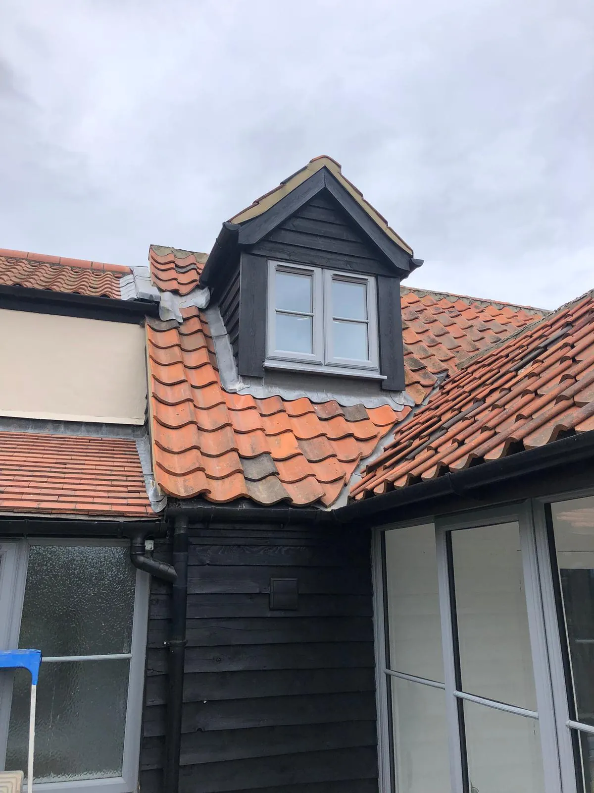 Black timber dormer and tiled roof on a house exterior