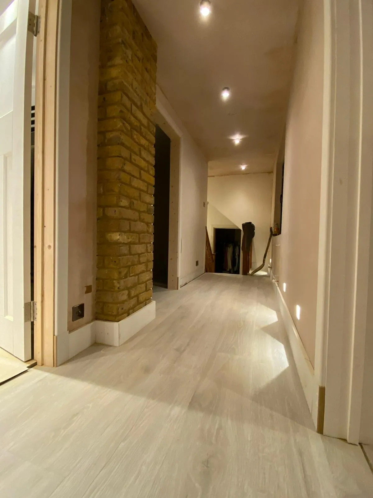 Corridor with a brick chimney breast and painted walls