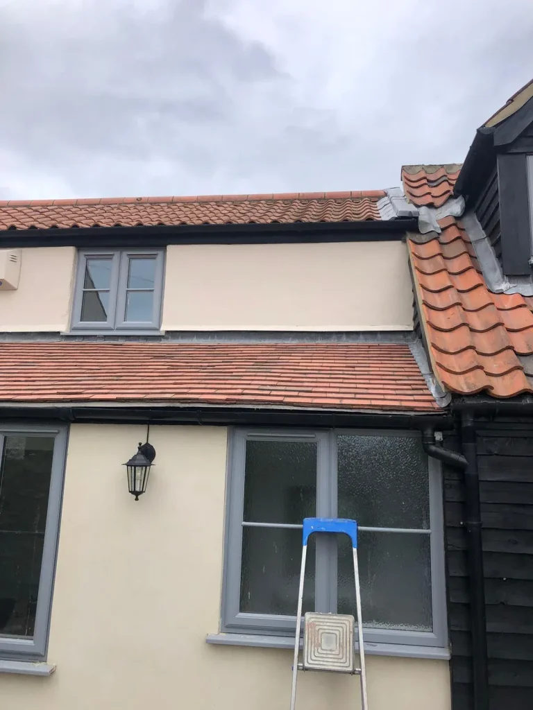 Cream painted render with grey window frames on a house exterior