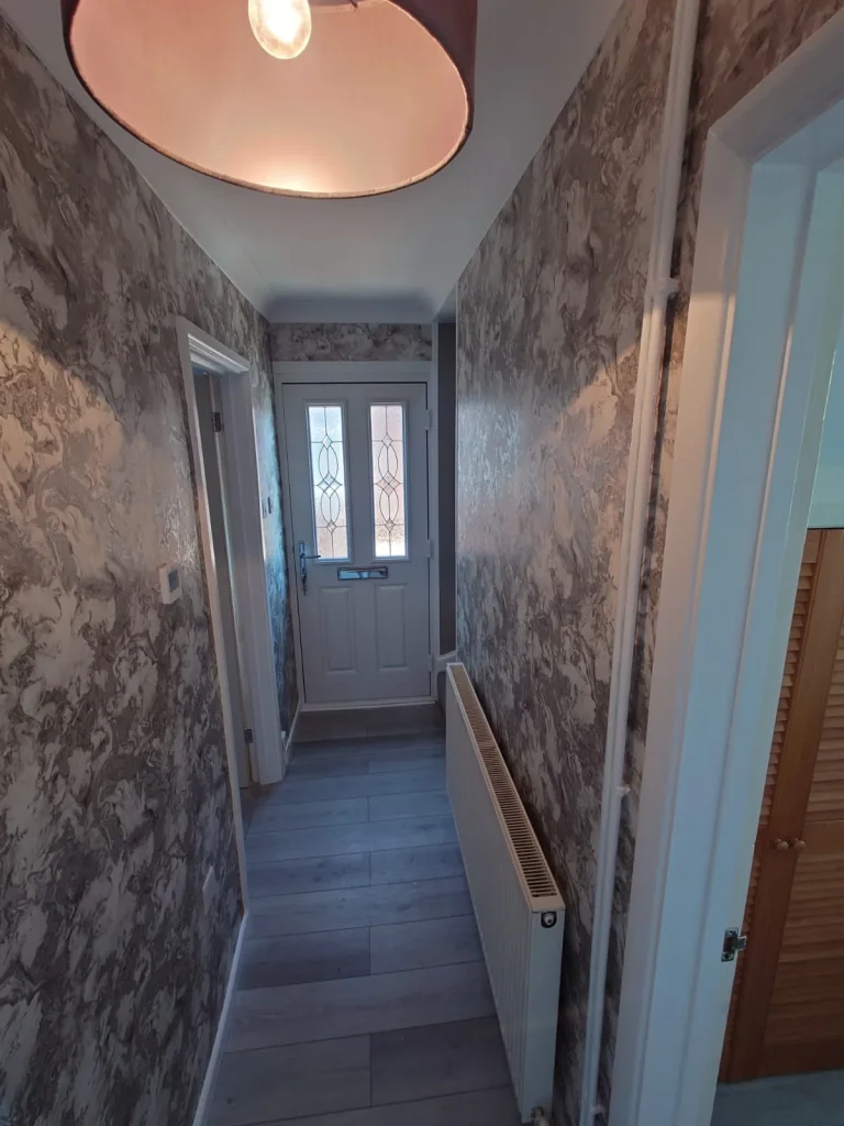 Hallway with marbled wallpaper and a pendant light