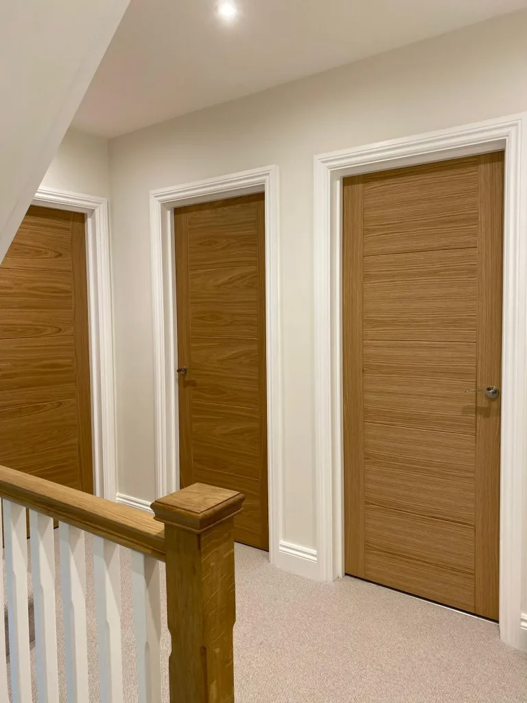Hallway with white painted walls, oak doors and a staircase