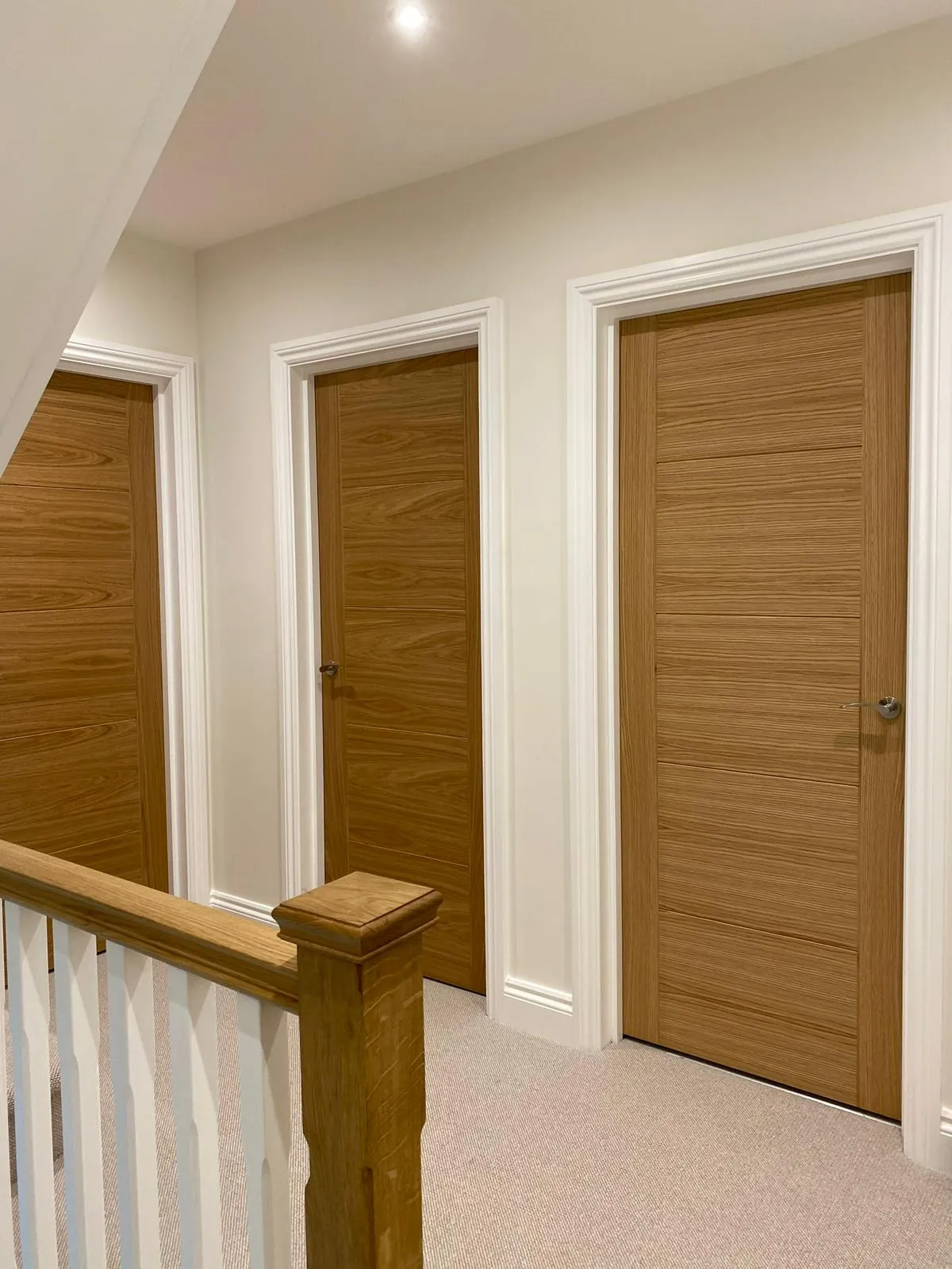 Hallway with white painted walls, oak doors and a staircase