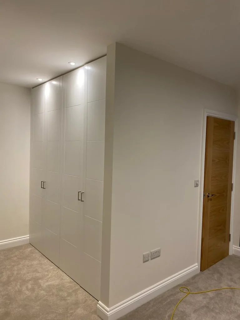 Hallway with white painted wardrobes and an oak door