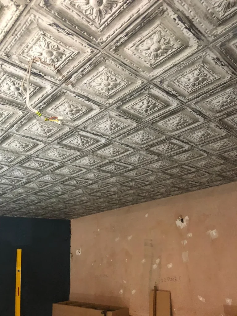 Decorative pressed-tin style ceiling in a room before redecoration