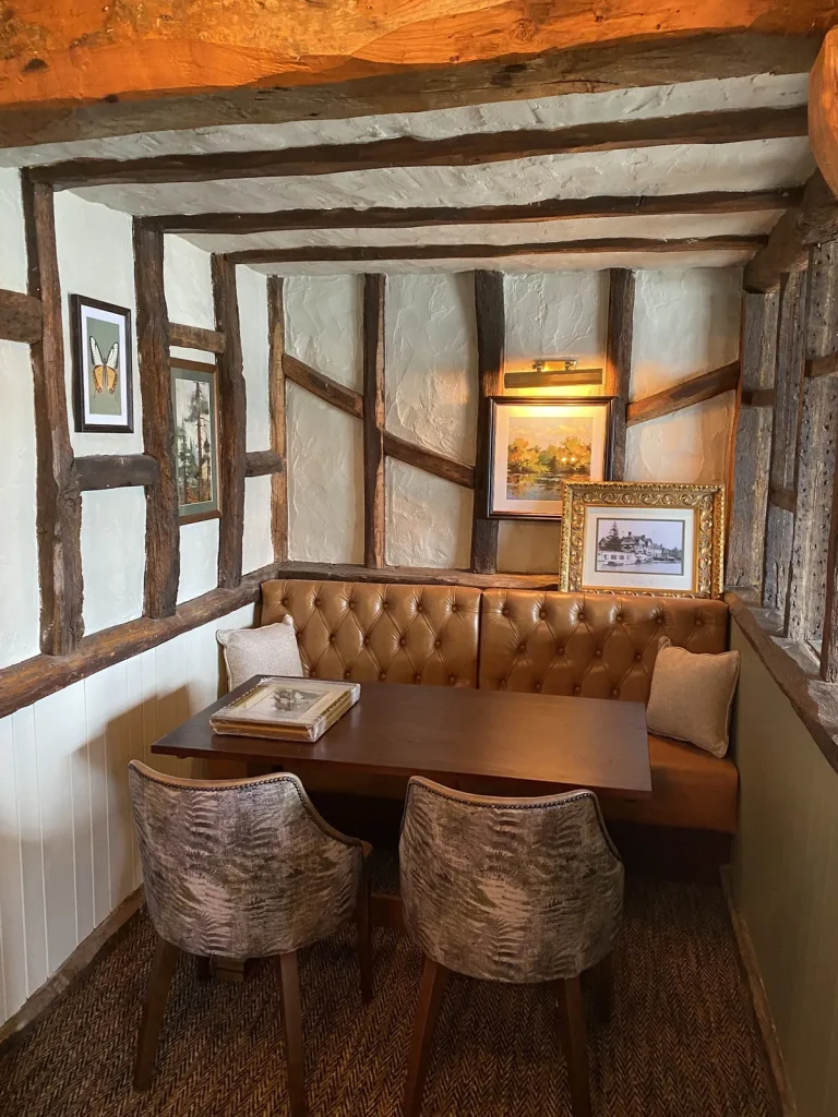 Timber-framed snug with leather seating and framed pictures